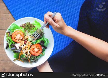 Overhead view of yoga woman eating fresh salad, Healthy eating and Working out concept
