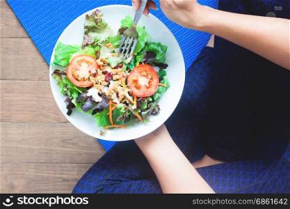 Overhead view of yoga woman eating fresh salad, Healthy eating and Working out concept