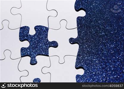 overhead view puzzle piece blue glitter background