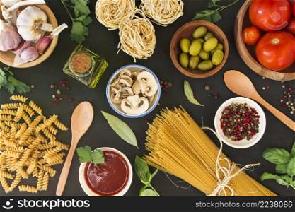 overhead view raw pasta with ingredients black background