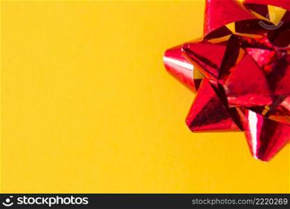 overhead view red ribbon bow yellow background