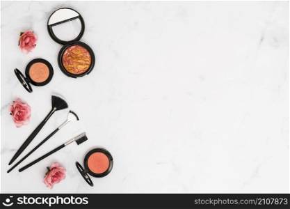 overhead view roses with compact face powder makeup brushes white background