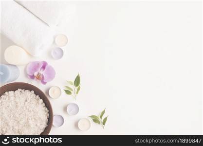 overhead view sea salt clay bowl with orchid candles rolled up towel white backdrop. Resolution and high quality beautiful photo. overhead view sea salt clay bowl with orchid candles rolled up towel white backdrop. High quality beautiful photo concept