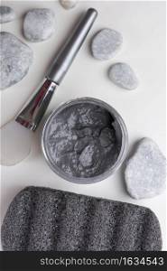 overhead view spa stones brush clay mask pumice stone white background