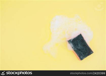 overhead view sponge with soap sud yellow background
