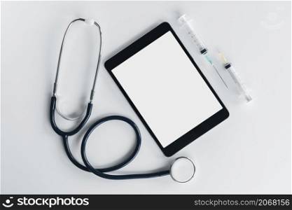overhead view stethoscope digital tablet syringe isolated white background