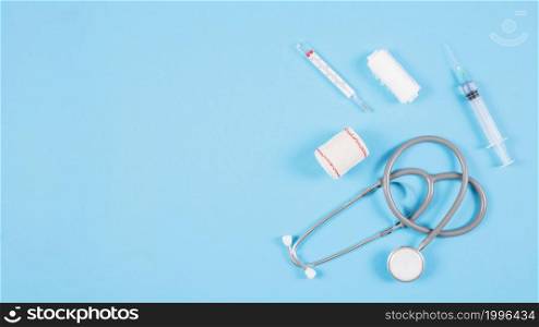 overhead view stethoscope with medical equipments blue background