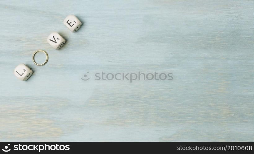 overhead view text made with cubes wedding ring corner wooden backdrop