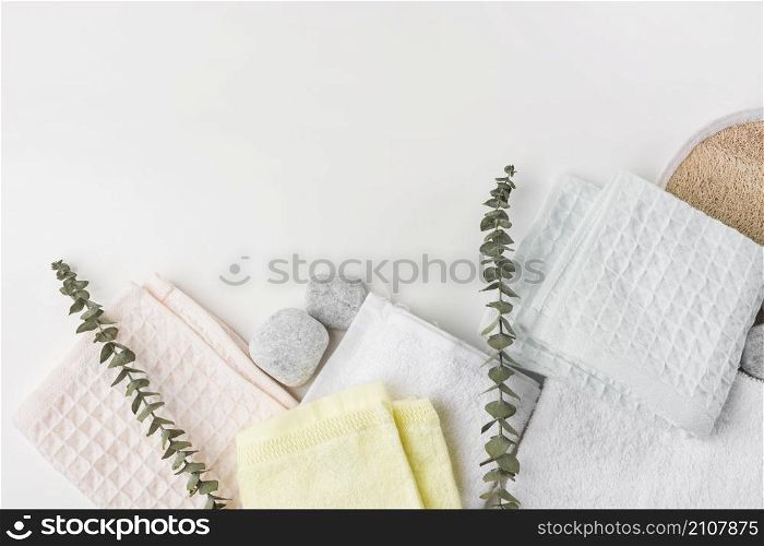 overhead view various folded napkins with spa stones twigs white background