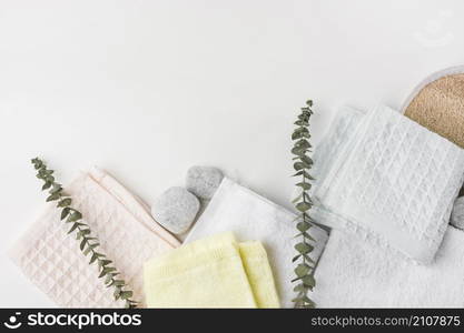 overhead view various folded napkins with spa stones twigs white background