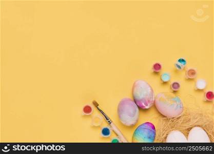 overhead view watercolor plastic bottle easter eggs corner yellow background