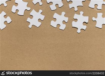 overhead view white puzzle pieces brown paper textured