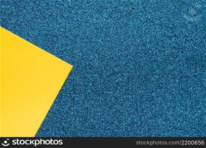 overhead view yellow cardboard paper blue surface