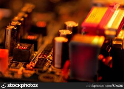 Overheated Transistor on Computer Board in Red and Gold Coolors
