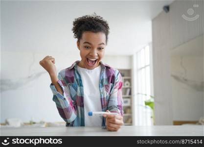 Overjoyed mixed race girl celebrates normal body temperature during coronavirus covid pandemic. Happy young lady holding thermometer, checking temp before travelling vacation, makes yes winner gesture. Overjoyed mixed race girl celebrates normal body temperature during coronavirus covid pandemic