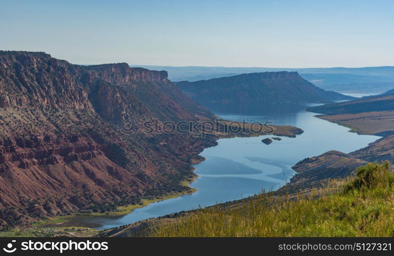 Overlooking Green River from the Flaming Gorge Green River Scenic Byway in Utah showing red-colored mountains and high desert plant life