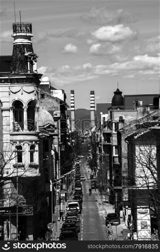 Overlooking to street in old part of city and two chimneys of heating plant at the bottom in black and white