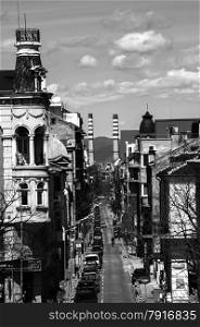 Overlooking to street in old part of city and two chimneys of heating plant at the bottom in black and white