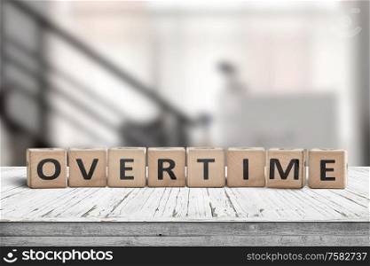 Overtime word spelled with wooden blocks in an office environment