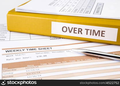 Overtime words on document binder place on blank weekly time sheets