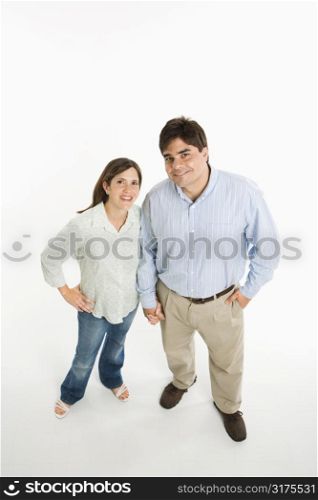 Overview of couple standing smiling against white background.