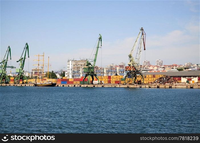 Overview of stacked containers and cranes at harbour