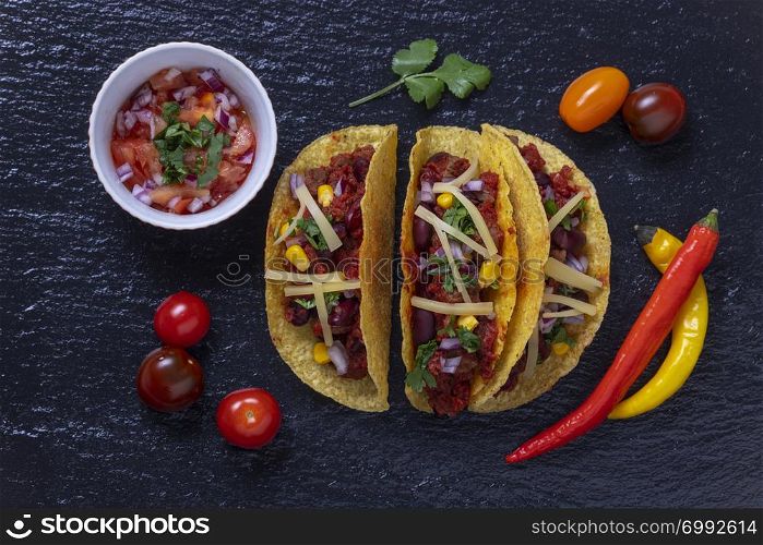 overview of three tacos on slate