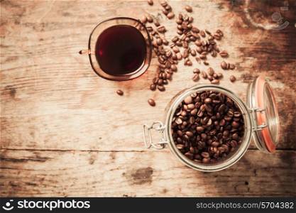 Overview shot of cup of coffee and beans on a wooden table