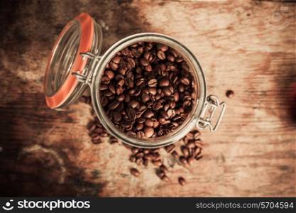 Overview shot of jar of coffee beans on a wooden table