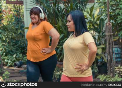 Overweight Asian women workout in the garden with her friend. Concept of Exercise to lose weight and maintain good health.