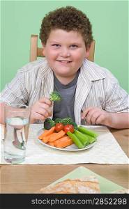 Overweight boy having healthy meal.