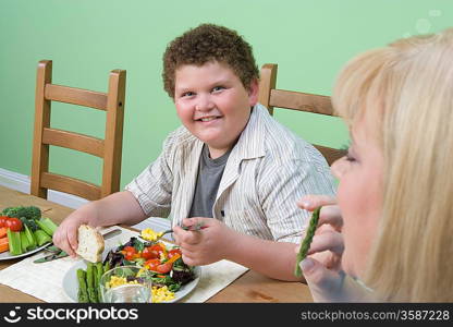 Overweight mother with overweight son having healthy meal