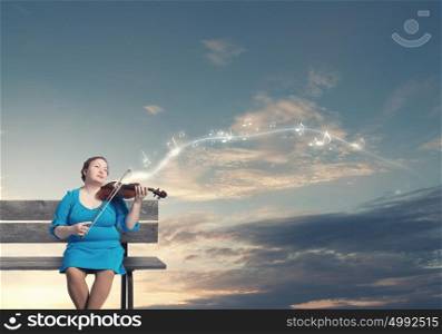 Overweight problem. Middle aged stout woman in blue dress sitting on bench and playing violin