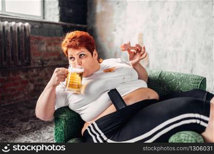 Overweight woman drinks beer and eats sandwich, bulimic, obesity. Unhealthy lifestyle, fatty female