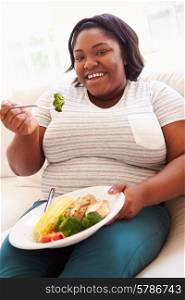 Overweight Woman Eating Healthy Meal Sitting On Sofa