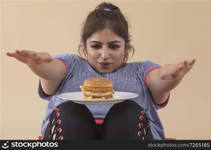 Overweight Woman Exercising with Burger