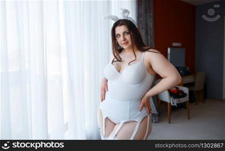 Overweight woman in erotic bunny costume. Sexy overweight girl with big breast, perverse large size lady. Overweight woman in erotic bunny costume
