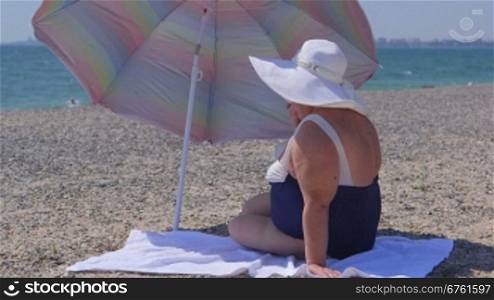 Overweight woman sunbathing on the beach