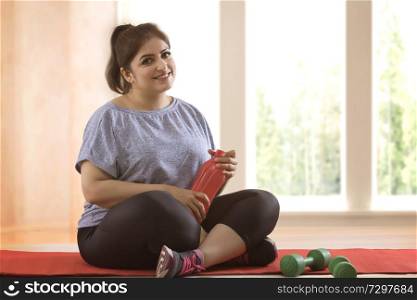 Overweight woman taking a break from exercising