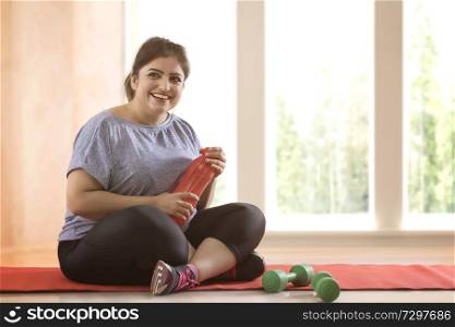 Overweight woman taking a break from exercising