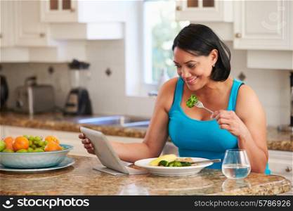 Overweight Woman With Digital Tablet Checking Calorie Intake
