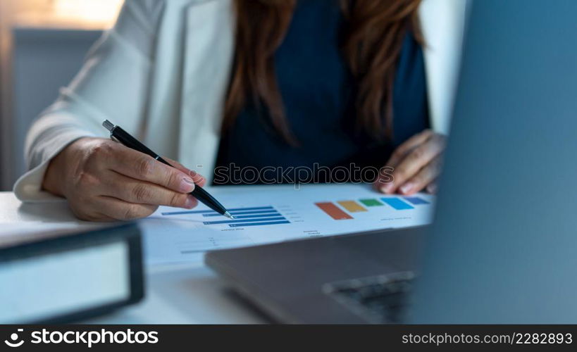 Overwork Concept The working woman sitting at her desk and writing her work on the paper.