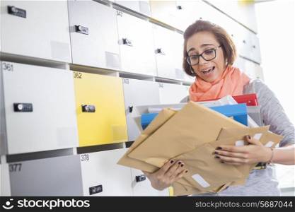 Overworked businesswoman holding documents in locker room at creative office