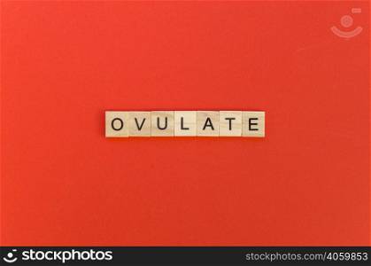 ovulate word with scrabble letters red background