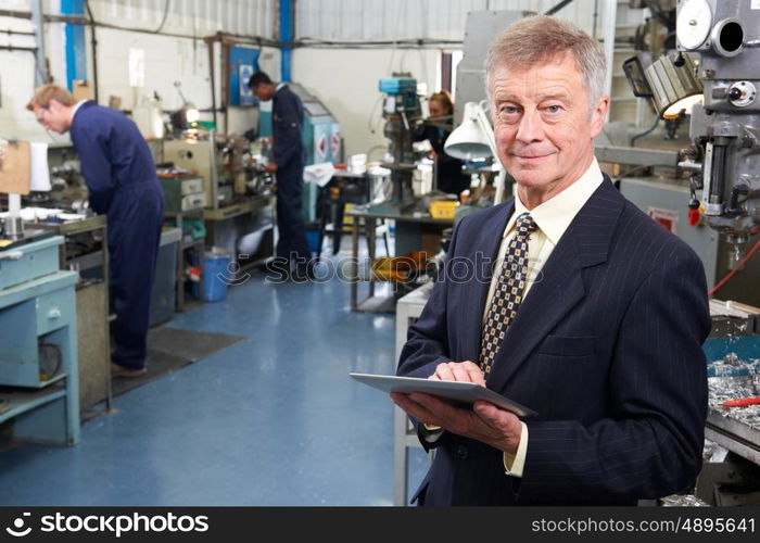 Owner Of Engineering Factory With Staff In Background