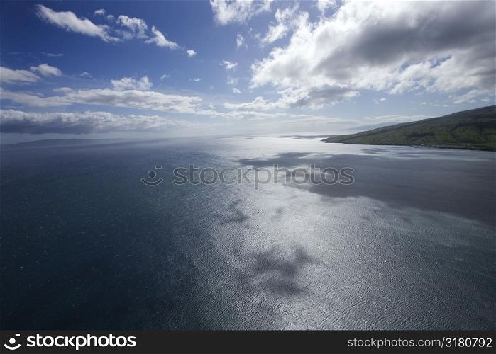 Pacific ocean and sky with clouds and corner of island in Hawaii.