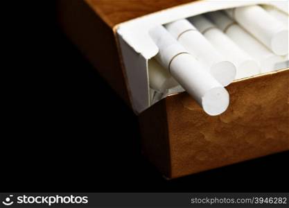 Pack of cigarettes close up over black background