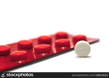 Pack of pills and one tablet on white