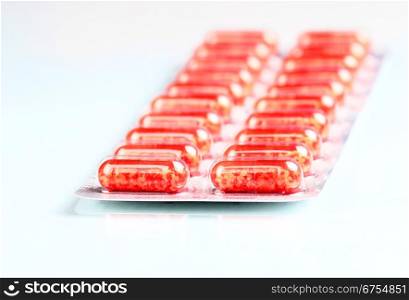 Pack of red pills isolated. Medical background