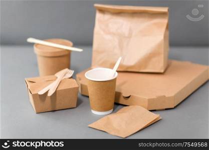 package, recycling and eating concept - disposable paper containers for takeaway food on table. disposable paper containers for takeaway food